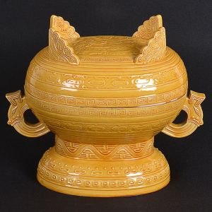 <b>Vaso de ritual com tampa </b>de forma oblonga "gui form" em cerâmica chinesa amarela decorada com motivos arcaicos. Mínimos bicados. Alt. 25 cm; Compr. 28 cm 