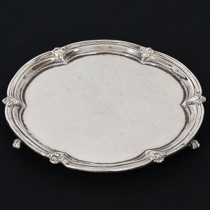 <b>Salva </b>circular em prata inglesa vitoriana. Fundo liso e borda ondulada decorada com estilizações e perolados. Pés em garras. Contraste da cidade de Londres de 1879 e marca de prateiro. Peso 270 g. Diâm. 21,5 cm