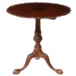 Belíssima <b>mesa de apoio </b>inglesa "tilt top", em "rosewood", apresentando tampo circular de aba recortada intercalada com acantos. Coluna central decorada com folhas e triplas pernas recurvadas terminadas em garras sobre esferas. Início do período vitoriano. Primeira metade do séc. XIX. Alt. 76 cm; Diâm. 77 cm