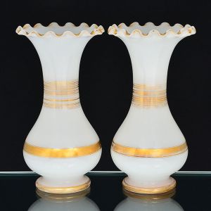 <b>Par de vasos </b>bojudos com bocal de corneta em opalina francesa branco leitoso e decoração com frisos a ouro. Borda em ondulações. Séc. XIX. Alt. 35 cm