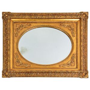 <b>Espelho </b>oval bisotado europeu, apresenta moldura retangular em madeira patinada a ouro e entalhada com lavrados vegetais. Moldura do séc. XIX, porém com pátina mais recente. Med. 92 x 82 cm