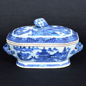 <b>Terrina para molho </b>de forma retangular com cantos chanfrados em porcelana Companhia das Índias decorada em azul índigo "underglaze" com personagens em paisagem lacustre com pagodes. Alças entrelaçadas e pega da tampa modelada em pinha. Fins do séc. XVIII. Compr. 19,5 cm