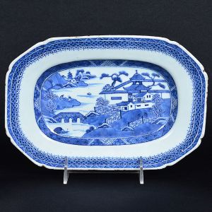 <b>Travessa </b>retangular com cantos chanfrados, em porcelana Companhia das Índias decorada com paisagem lacustre e pagodes em azul índigo "underglaze" sobre fundo branco. Borda com arabescos. Fins do séc. XVIII ou início do XIX. Med. 25 x 17 cm