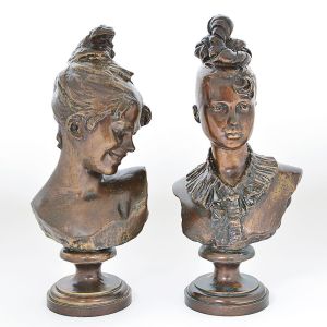 <b>RODOLFO BERNARDELLI</b> <br>(1851-1931) <br>Conjunto de duas esculturas em bronze patinado representando bustos de mulher. Ass. na parte posterior. Alt. 40 e 38,5 cm