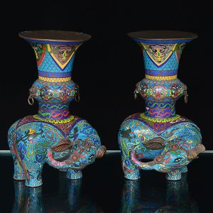 Belo <b>par de vasos </b>em "cloisonné" ricamente policromado e apoiados em figuras de elefantes. Séc. XIX. Alt. 29,5 cm; Compr. 19 cm