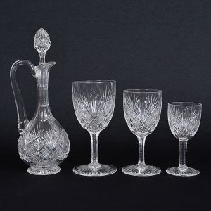 <b>Conjunto de copos </b>em cristal francês, St. Louis, lapidado em geometrizados com hastes serrilhadas. Constando de 22 taças p/ água e 24 taças p/ vinho em 2 tamanhos, sendo 12 de cada. Acompanha licoreira (tampa presa). Total de 47 peças. Alt. da licoreira 26,5 cm; Alt. dos copos 17, 15 e 12,5 cm