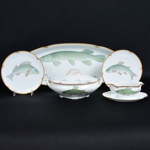 <b>Serviço de jantar </b>em porcelana alemã decorada com diversos peixes pintados a mão e policromia de tonalidade verde com filetados a ouro. Marca da manufatura e do artista Friedrich Henseler - Bremen. Constando de 18 pratos rasos (23 cm), 1 molheira (23 cm), 1 travessa (62 cm), 1 sopeira (29 cm). Total de 21 peças.