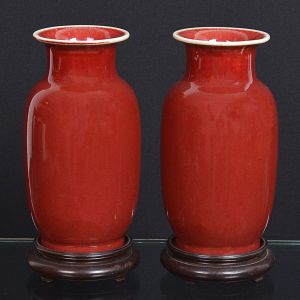 <b>Par de vasos </b>em porcelana chinesa na tonalidade sangue de boi. Acompanha bases em madeira. Alt. dos vasos sem base 23,5 cm