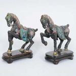 <b>Par de esculturas </b>modeladas em cavalos em "cloisonné" sobre base de madeira. Ambas faltando uma orelha. Alt. 13,5 cm; Compr. 13 cm