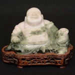 Antiga <b>estatueta</b> chinesa em jade representando "Buddha Sorridente". Base em madeira. Séc. XIX / XX. Alt. 7,5 cm; Compr. sem a base 12 cm