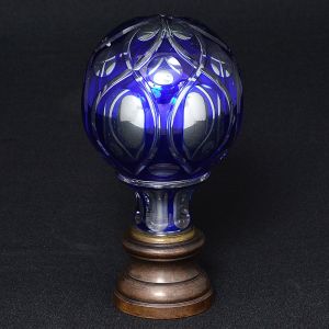 <b>Pinha </b>globular francesa na cor azul cobalto e interior espelhado. Lapidação geometrizada com florácea ao topo. Base em bronze. Alt. 16,5 cm