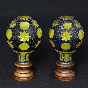 <b>Par de pinhas </b>globulares, francesas, em opalina, com "overlay" azul marinho texturizado. Decoração com círculos e elementos estrelares. Base em bronze. Alt. 16,5 cm