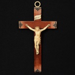 Pequeno <b>crucifixo </b>em madeira com a imagem entalhada em marfim e pequenos adereços metálicos nas pontas. Alt. 24 cm