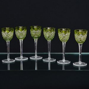 Maison BACCARAT - <b>Conjunto de 12 copos de pé alto </b>em cristal francês, com bojos na cor verde e lapidação geometrizada. Marca da "cristallerie" no verso. Alt. 20 cm