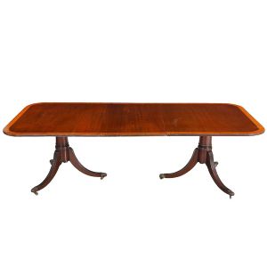 Antiga <b>mesa de jantar </b>inglesa em mogno, construída no sistema elástico. Tampo retangular de quinas arredondadas e borda decorada em madeira clara, "wood cherry". Dois montantes cilíndricos sobre pernas recurvadas e filetadas. Pés em garras sobre rodinhas. Med. 73 x 244 x 114 cm