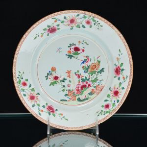 <b>Prato raso </b>circular em porcelana Companhia das Índias, decorado em policromia florida com peônias nos esmaltes da Família Rosa. Séc. XVIII. Fio de cabelo de 5 cm e mínimos bicadinhos na borda. Diâm. 23 cm