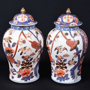 <b>Par de potiches </b>em porcelana chinesa em forma de bulbos decorados em "rouge de fer" e azul índigo em diversas composições floridas, pássaros e frutos. Realce a ouro. Marca no verso. Alt. 50 cm