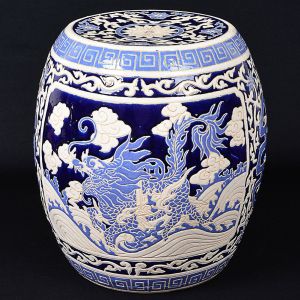 "<b>Garden seat</b>" chinês em porcelana, em forma de tamborete, profusamente decorada com arabescos. Duas grandes reservas com aves e arabescos floridos e geometrizados em azul e branco. Laterais vazadas. Alt. 44 cm