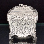 "<b>Tea caddy</b>" em prata inglesa decorada com pagodes, aves e composições floridas. Pés em volutas reviradas. Contraste da cidade de Londres de 1758 e marca do prateiro JOHN PAYNE. Peso 265 g. Med. 11 x 10 x 7,5 cm