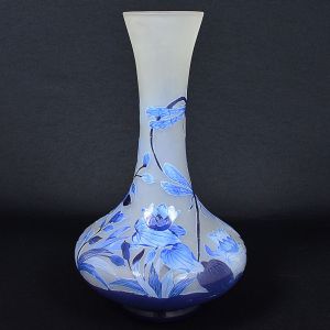 <b>Vaso</b> bojudo de gargalo alongado, em pasta de vidro, decorado em várias tonalidades de azul com libélulas, flores e folhagens sobre fundo "satiné". Assinatura não identificada na base. Alt. 40 cm