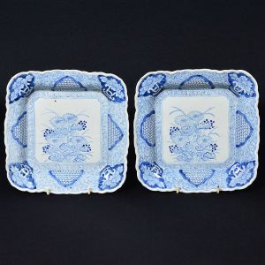 <b>Par de covilhetes </b>em porcelana japonesa, de feitio quadrado e decoração com flores e arabescos. Abas onduladas. Séc. XIX. Med. 25 x 24,5 cm