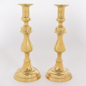 <b>Par de castiçais </b>em bronze dourado com hastes em segmentos de balaústre e bases circulares. Timbre do fabricante John Sommers de Minas Gerais. Alt. 24,5 cm