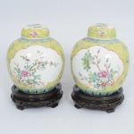 <b>Par de potiches</b> bojudos em porcelana chinesa do séc. XIX, apresentando duas grandes reservas floridas em policromia sobre fundo amarelo com arabescos. Alt. 21 cm