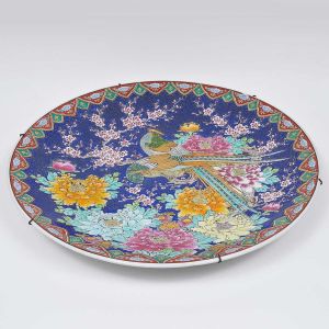 Monumental<b> medalhão </b>circular em porcelana chinesa, ricamente decorado em policromia e ouro com figuras de fênix entre ramagens com peônias e flores de cerejeira. Borda com arabescos. Diâm. 62 cm