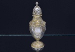 Elegante <b>polvilhador </b>em prata europeia repuxado e cinzelado com duas reservas emolduradas por guirlandas intercaladas por alegorias. Base abobadada decorada com estilizações vegetais. Pega em forma de pinha. Contraste e marca de prateiro do séc. XIX. Peso 150 g. Alt. 18,5 cm