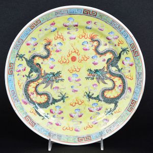 <b>Prato</b> circular em porcelana chinesa decorada com dragões celestiais em verde sobre fundo amarelo. Borda em gregas. Mínimos restauros na borda. Diâm. 25,5 cm