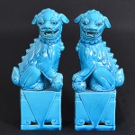 <b>Casal de cães de fó</b>, apoiados sobre pedestal, em porcelana chinesa coberta por esmalte turquesa. Alt. 24,5 cm