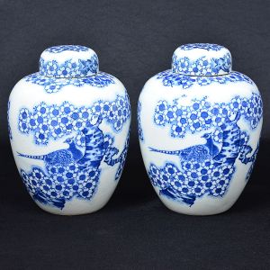 <b>Par de potiches </b>em porcelana chinesa, decorados em azul índigo com flores e figura de pavão sobre fundo craquelê. Alt. 22 cm