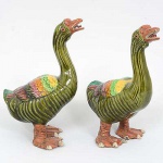 <b>Par de antigas esculturas </b>chinesas em cerâmica modeladas em figuras de patos com policromia predominando a tonalidade verde. Uma das unhas colada. Alt. 30,5 cm; Compr. 19 cm