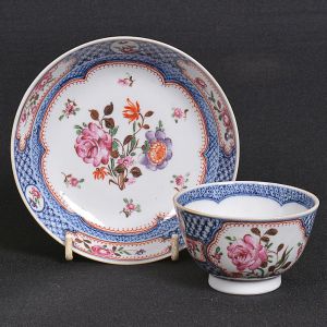 Pequeno <b>"bowl" com seu pires</b>, "teacup and saucer", em porcelana Companhia das Índias decorada com arranjos floridos em policromia da Família Rosa em arabescos e azul índigo "underglaze". Diâm. do "bow" l 7,5 cm; Diâm. do pires 12,5 cm