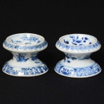 <b>Par de saleiros </b>circulares em porcelana Companhia das Índias, decorados com composições floridas em azul índigo "underglaze". Séc. XVIII. Alt. 6 cm; Diâm. 8 cm