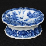 <b>Saleiro </b>oblongo de borda ondulada em porcelana Companhia das Índias, decorado em azul índigo sobre fundo branco com paisagem lacustre e casario. Séc. XVIII. Compr. 9 cm