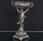 <b>Centro de mesa ou floreira </b>de época e estilo Art Nouveau em estanho representando figura feminina parcialmente desnuda sobre base vazada. Séc. XIX. Alt. 36 cm