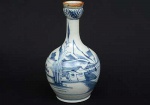 <b>Vaso</b> bojudo de gargalo alongado em porcelana chinesa Macau decorada em azul índigo "underglaze" com paisagem, casario e embarcações. Bocal em geometrizados. Séc. XIX. Alt. 21 cm