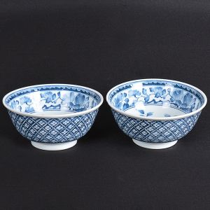 <b>Par de "bowls" </b>em porcelana japonesa azul e branco decorada com arabescos e flores. Marca no verso. Um com pequeno bicado na borda. Alt. 6 cm; Diâm. 15 cm