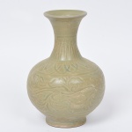 <B>Vaso</b> balaústre em porcelana chinesa, revestido por coberta celadon do tipo Yaozhou, ornado por incisões com larga faixa floral à meia altura e frisos estilizados com pétalas e nuvens. Bojo globular, encimado por gargalo com borda revirada. Base circular retraída. Dinastia Yuan (1279-1368). Marcas de colecionadores sob a base. Alt. 15 cm