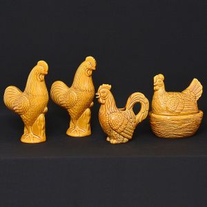 <b>Conjunto de elegantes peças em cerâmica </b>provençal em porcelana na cor mostarda. Constando de par de galos, terrina e jarra em forma de galinha. Alt. dos galos 33,5 cm; Compr. da terrina 24,5 cm