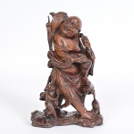 Antiga <b>escultura </b>em madeira chinesa representando buda sentado com figura infantil e esquilo aos pés. Parte da cabeça fraturada. Alt. 25 cm