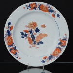 Grande <b>medalhão </b>circular em porcelana Companhia das Índias, decorado em policromia "Chinese Imari", com folhas e folhagens predominando as tonalidades características de azul índigo, "rouge de fer" e ouro sobre fundo branco. Grande fio de cabelo. Diâm. 39 cm