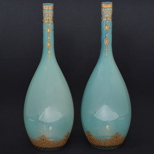 <b>Par de vasos </b>venezianos, formato gota, com gargalo cilíndrico alongado, em vidro opalinado, na cor azul. Decoração com arabescos a ouro. Alt. 49 cm