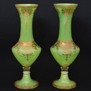 Elegante <b>par de vasos</b> venezianos, em vidro opalinado na cor verde. Apresentam formato balaústre e rica decoração a ouro. Alt. 47 cm