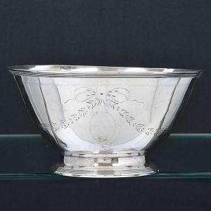 "<b>Bowl</b>" em prata lavrada com guirlandas e laços sobre elemento oval ondulatório. Borda filetada. Provável vestígio de contraste na base. Séc. XVIII / XIX. Peso 245 g. Alt. 8 cm; Diâm. 15 cm