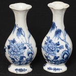 <b>Par de pequenos vasos </b>piriformes de gargalo alongado em porcelana Companhia das Índias, decorados em ramagens e flores em azul índigo "underglaze" sobre fundo branco. Séc. XVIII. Mínimo bicadinho na borda de um deles. Alt. 14 cm