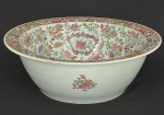 Grande <b>bacia</b> circular em porcelana chinesa ricamente policromada tendo ao fundo figuras de cortesãs em paisagem com terraço. Restante do bojo com profusão de flores, frutos, objetos preciosos e insetos. Alt. 16,5 cm; Diâm. 47,5 cm