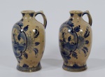 Par de jarras com alça em porcelana holandesa, DELFT, com policromia na tonalidade azul. Ambas as peças possuem pequeno lascado na base. Altura: 21 cm.