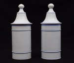 Par de potes de farmácia em faiança na cor branca com frisos azuis. Diâmetro: 13 cm. Altura: 35 cm.